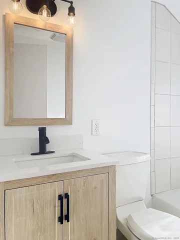 a bathroom with a sink toilet and mirror