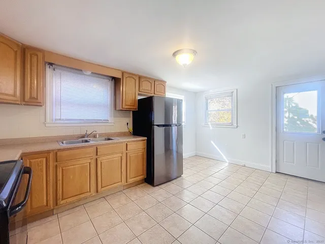 a kitchen with a refrigerator sink and cabinets