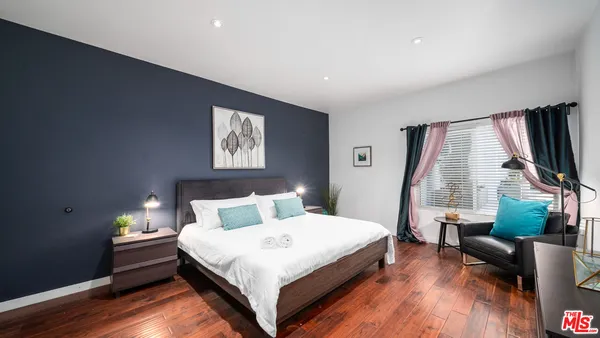 a bedroom with a bed and a flat screen tv