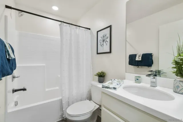 a bedroom with bed and a potted plant on dresser