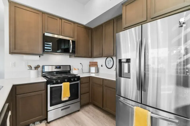a kitchen with stainless steel appliances granite countertop a stove a refrigerator and a microwave