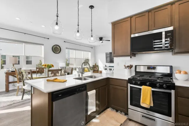 a kitchen with stainless steel appliances a stove a sink dishwasher and a microwave oven with white cabinets