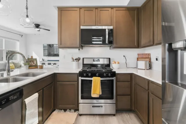 a kitchen with stainless steel appliances granite countertop a sink stove and microwave