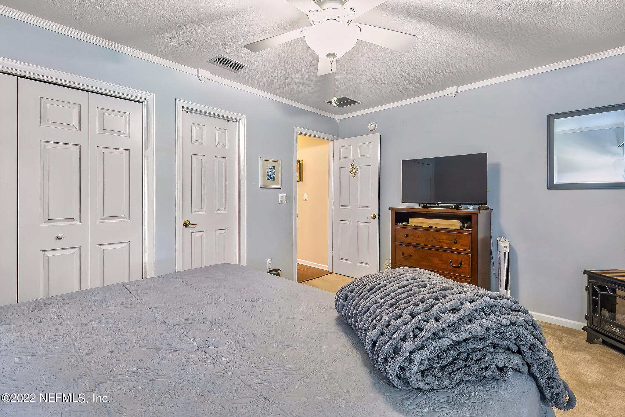 855 East Red House Branch Road St. Augustine, FL 32084 - Photo 29 of 43 a bedroom with a bed and a flat tv screen on dresser
