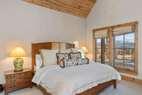 a bedroom with a bed a lamp and a large window