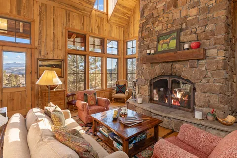 a living room with furniture a fireplace and a floor to ceiling window