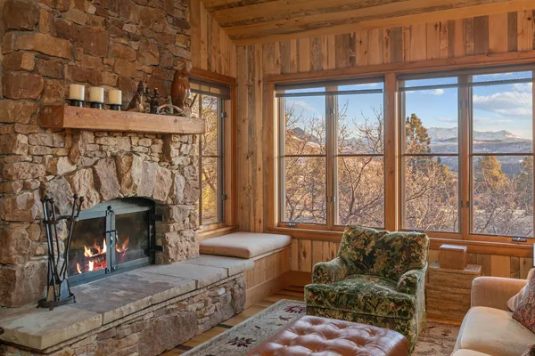 a living room with furniture a fireplace and a floor to ceiling window