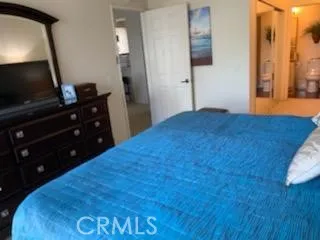 a bedroom with a bed and a flat tv screen on dresser