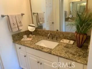 a bathroom with a granite countertop sink and a mirror