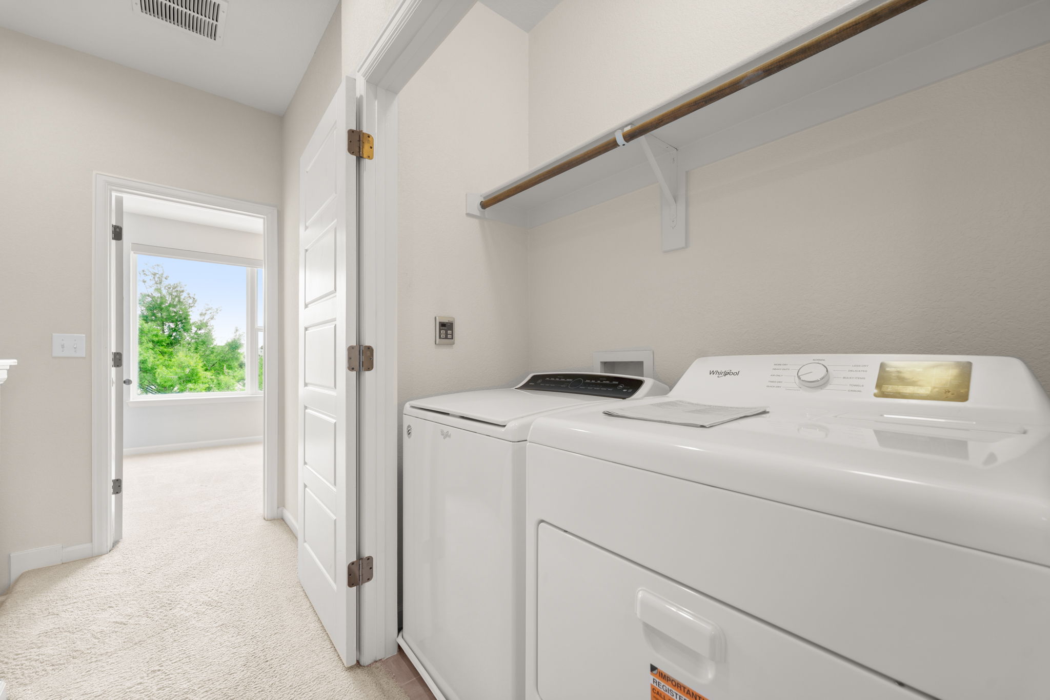 4403 Swift Path Austin, TX 78741 - Photo 18 of 32 Dedicated laundry area featuring a white washer and dryer set, an overhead storage shelf, and a hanging rod