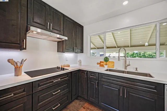 a kitchen with stainless steel appliances a sink a stove and a window