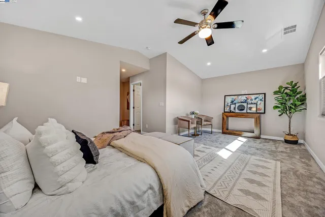 a spacious bedroom with a bed and a chandelier