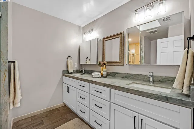 a bathroom with a granite countertop sink and a mirror