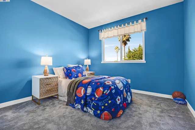 a bedroom with a bed and painting on the wall