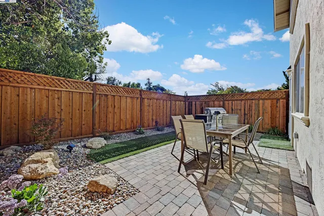 a view of a chairs and table in the back yard of the house