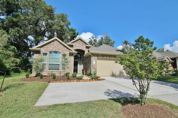 a front view of a house with a yard and potted plants