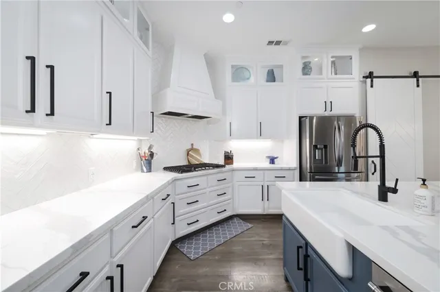a kitchen with white cabinets and sink