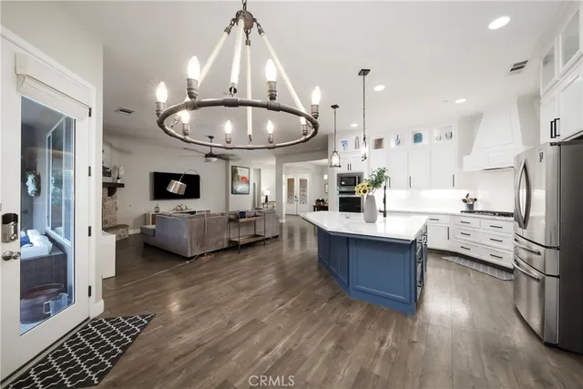 a large room with kitchen island stainless steel appliances a stove a sink a refrigerator and center island