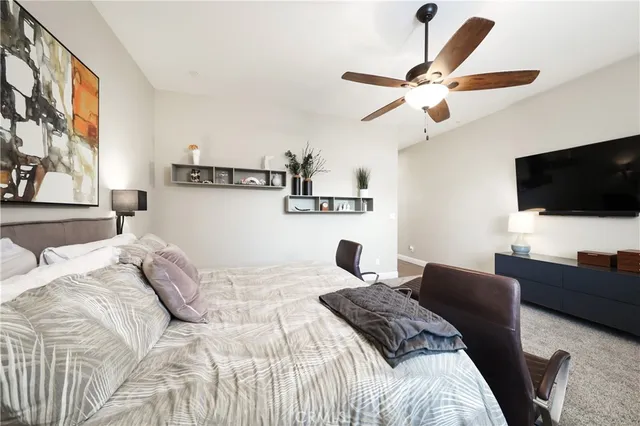 a bedroom with a bed window and a flat screen tv