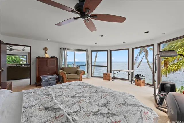 a bedroom with a bed a large window and furniture