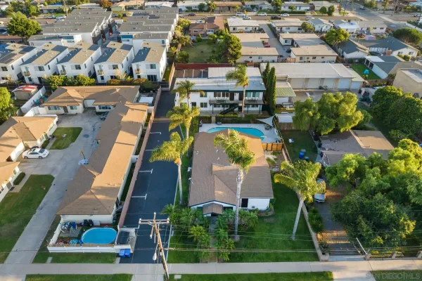 an aerial view of residential houses with outdoor space and swimming pool