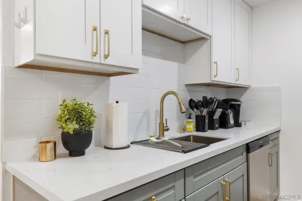 a kitchen with a sink a potted plant and a wooden floor