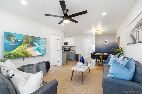 a living room with furniture kitchen view and a flat screen tv