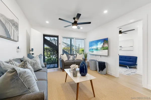 a living room with furniture a ceiling fan and a window