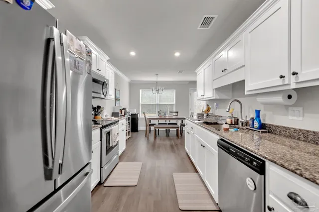 a kitchen with white cabinets and appliances