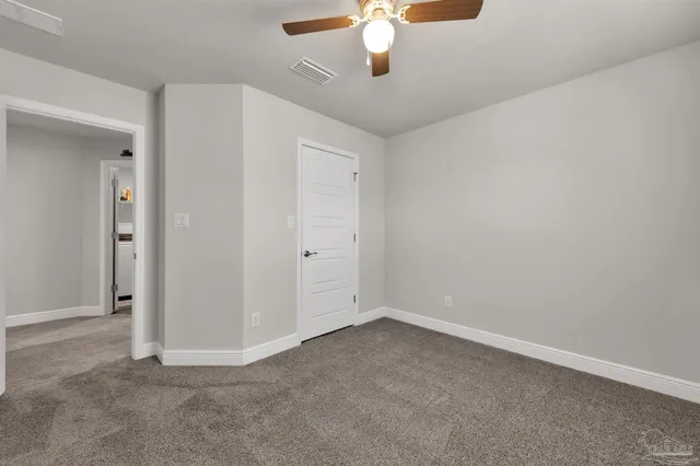 an empty room with a chandelier fan
