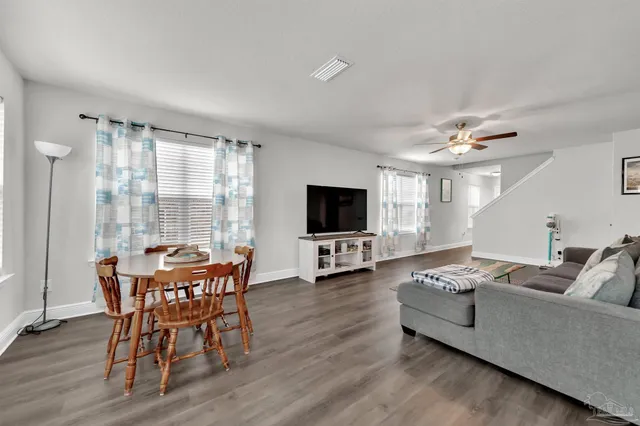 a living room with furniture a flat screen tv and a large window