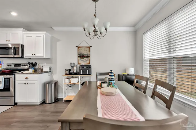 a living room with stainless steel appliances granite countertop furniture and a wooden floor