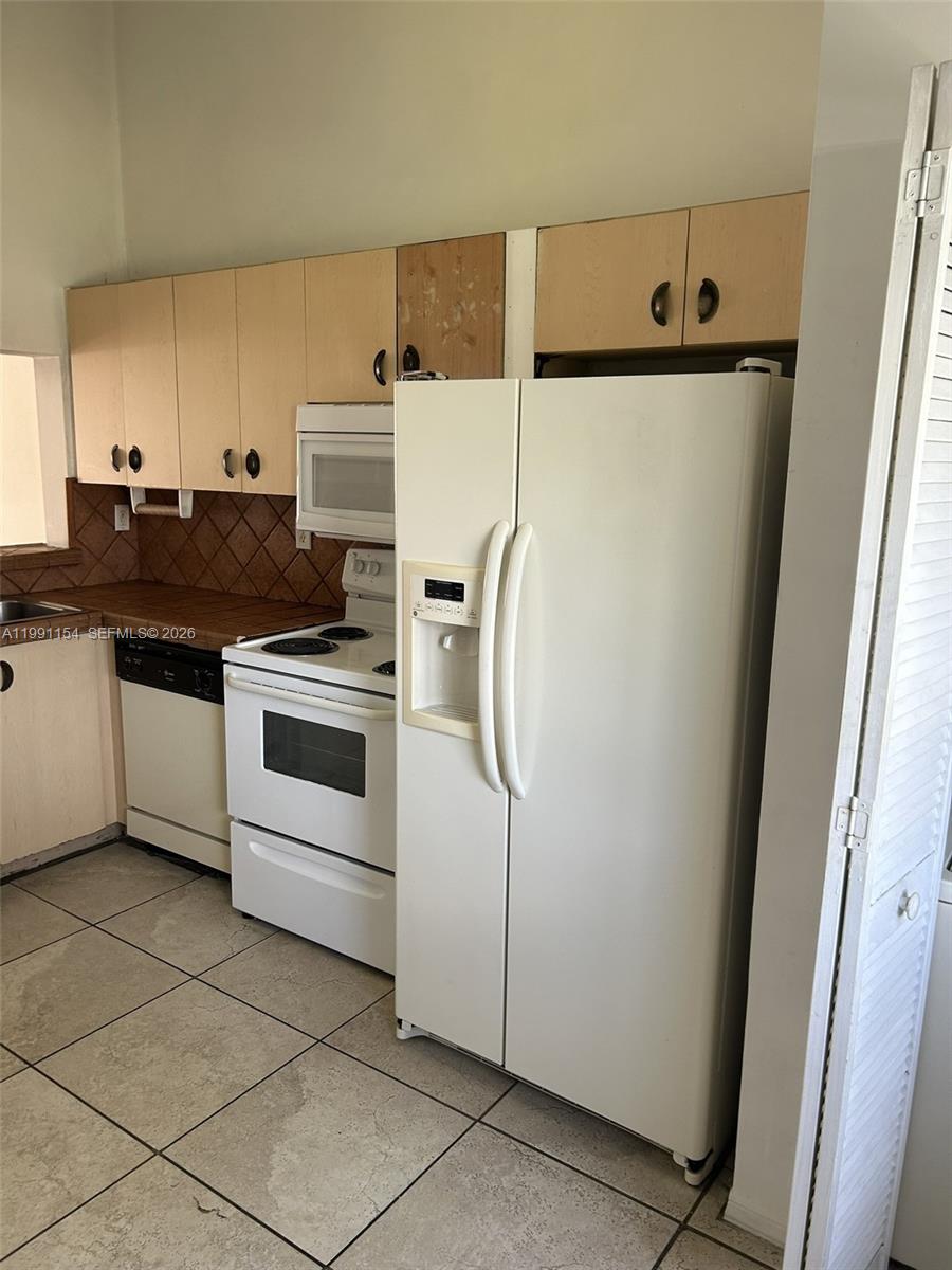 6425 Southwest 130th Place, Unit 704 Miami, FL 33183 - Photo 5 of 6 a kitchen with a stove and a refrigerator