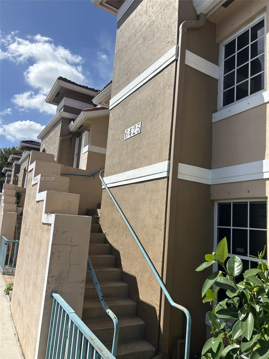 6425 Southwest 130th Place, Unit 704 Miami, FL 33183 - Photo 6 of 6 a view of staircase with wooden floor and a potted plant