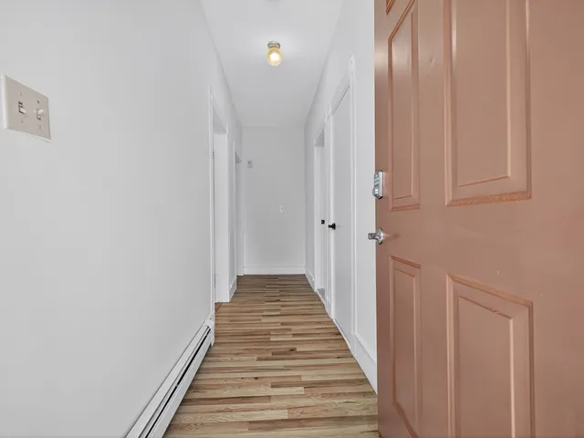 a view of a hallway with wooden floor and staircase