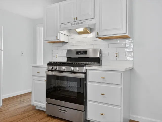 a kitchen with granite countertop white cabinets and appliances