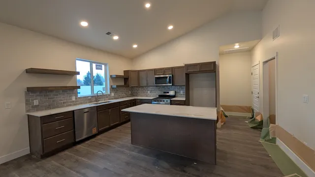 a large kitchen with kitchen island a sink stainless steel appliances and cabinets