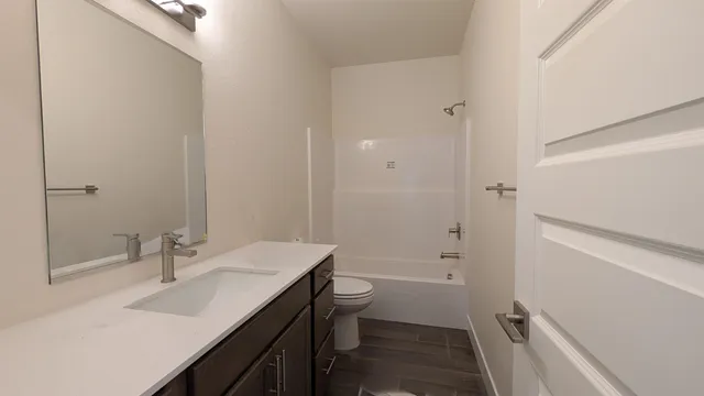 a bathroom with a sink a toilet a shower and a mirror