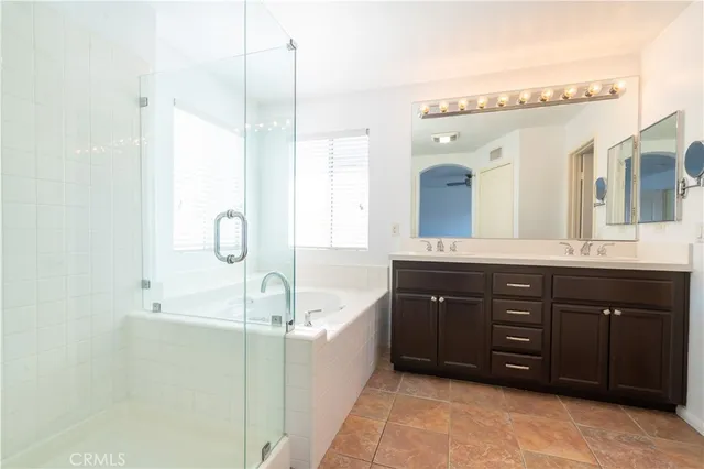 a bathroom with a tub sink double vanity and mirror