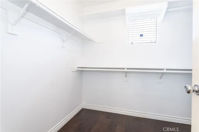 an empty room with wooden floor chandelier fan and windows