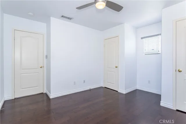 an empty room with wooden floor and mirror