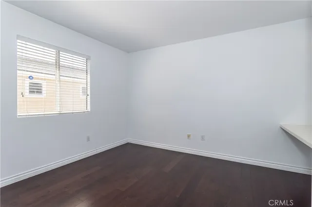 an empty room with wooden floor & cabinet