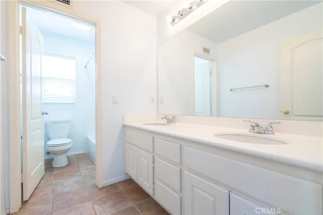 a white toilet sitting next to a bath tub