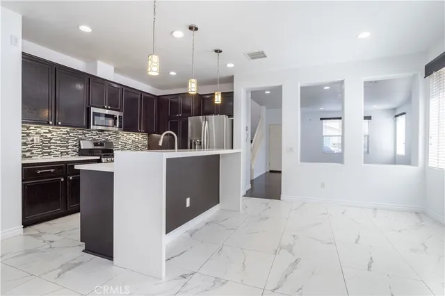 a kitchen with kitchen island a counter top space appliances and a cabinets