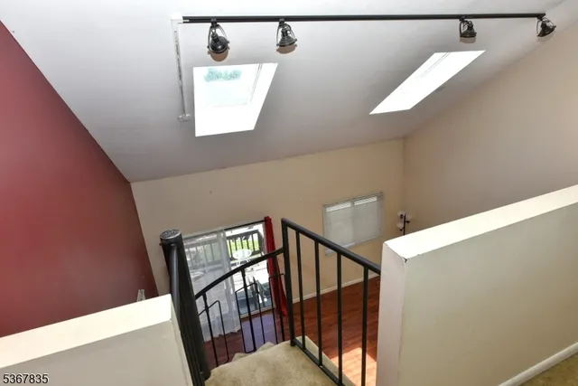 a view of staircase with lots of frames on wall and a window