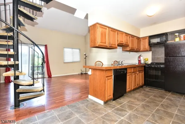 a kitchen with stainless steel appliances kitchen island granite countertop a refrigerator a stove a sink and dishwasher