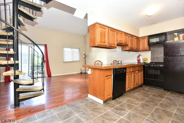a kitchen with stainless steel appliances kitchen island granite countertop a refrigerator a stove a sink and dishwasher