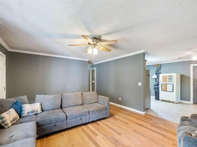 a living room with furniture and a ceiling fan