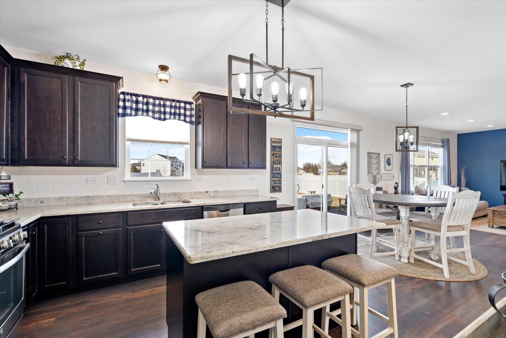 435 Fawn Lane Oswego, IL 60543 - Photo 7 of 26 a dining room with wooden floor a chandelier a wooden table and chairs