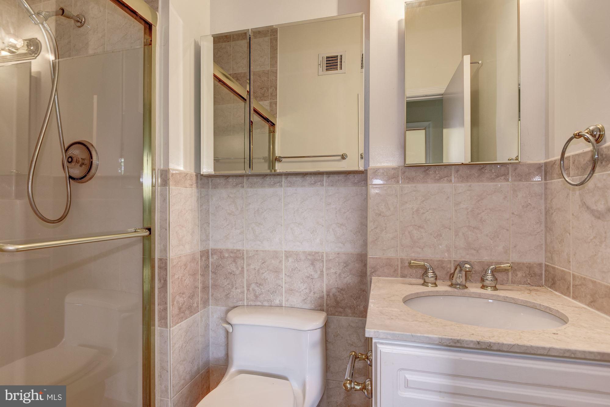2045 North Glebe Road Arlington, VA 22207 - Photo 12 of 19 a bathroom with a granite countertop toilet sink and mirror
